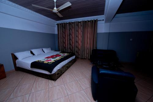 a bedroom with a bed and a ceiling fan at Pemicsa Hotel Accra in Spintex