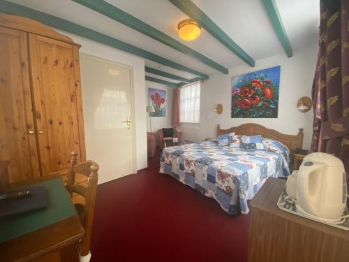 a bedroom with a bed and a table with avertisement at Hotel & Restaurant De Fortuna in Edam