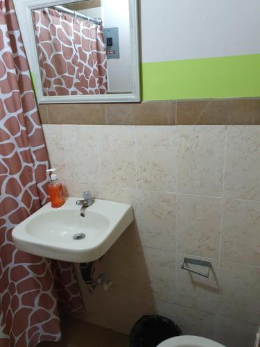 y baño con lavabo, espejo y aseo. en Hotel Kasa Kamelot Central, en Quetzaltenango