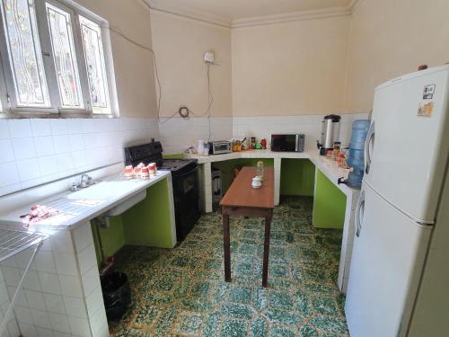 a kitchen with a refrigerator and a table in it at Hotel Kasa Kamelot Central in Quetzaltenango