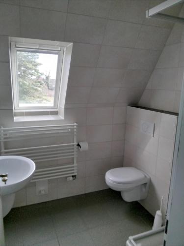 a bathroom with a toilet and a sink and a window at Ferienwohnung 4 Haus Neptun Ideal für Familien mit Kindern in Büsum