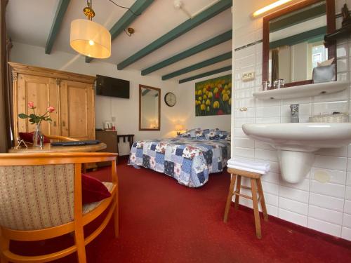 a bathroom with a sink and a bed in a room at Hotel & Restaurant De Fortuna in Edam