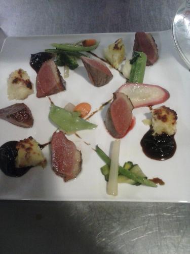a plate of food with meat and vegetables on it at Logis Hôtel Restaurant Gilles Moreau Laguiole in Laguiole
