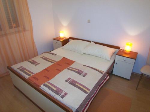 a bedroom with two lights on two night stands and a bed at Apartments Croatia Brač in Supetar