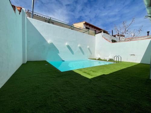 a backyard with a swimming pool and green grass at Casa en CARABAÑA a 30 minutos de MADRID in Carabaña