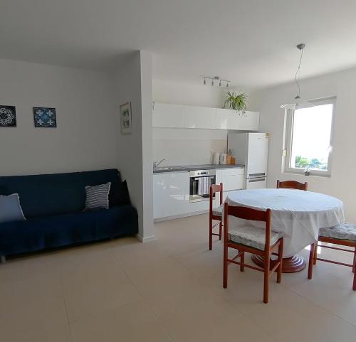 ein Wohnzimmer mit einem Tisch und einem blauen Sofa in der Unterkunft Sea View Apartments in Selca