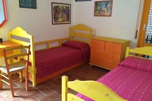 een slaapkamer met 2 bedden, een tafel en een bureau bij Appartamento a pochi passi dal mare con servizio spiaggia incluso in Terracina