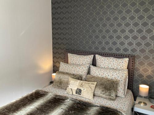 um quarto com uma cama com uma parede cinzenta em Studio Urban Chic Annecy em Annecy