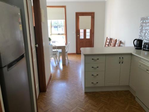 a kitchen with a white counter and a dining room at Serenity on Sturt in Ballarat