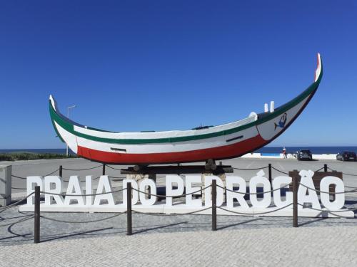 a sign for a beach with a boat on it at Praia do Pedrógão in Pedrógão