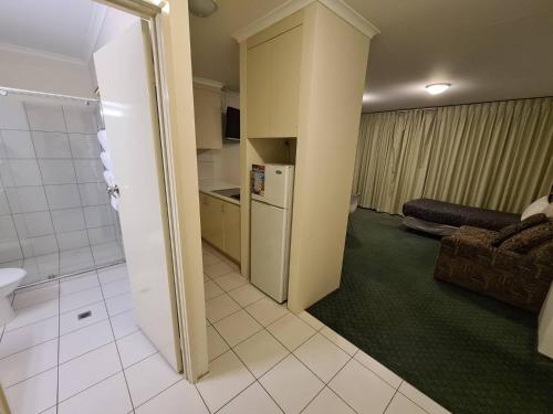 a living room with a refrigerator and a kitchen at Cottonwood Motor Inn in Mildura