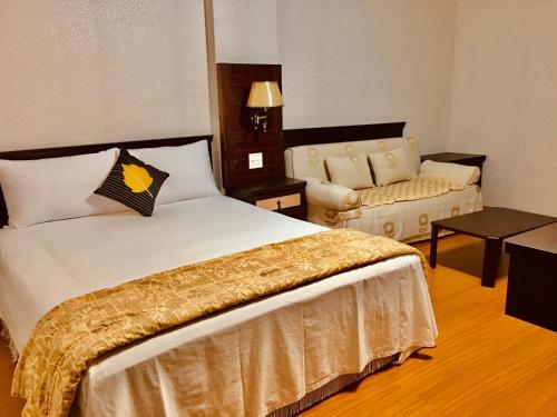 a hotel room with a bed and a couch at Chulu Wenxin Xiao Zhan Homestay in Chulu