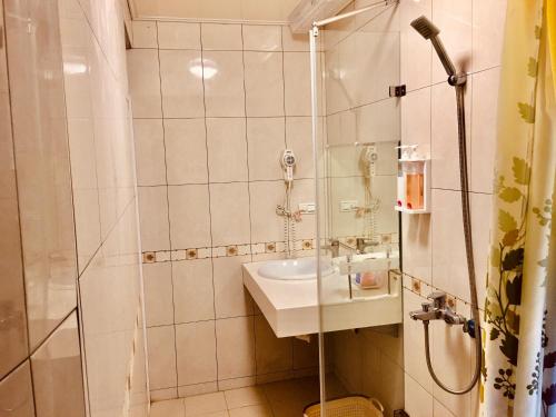 a bathroom with a shower and a sink at Chulu Wenxin Xiao Zhan Homestay in Chulu