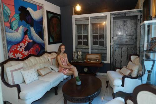 a woman sitting on a couch in a living room at Batey Hotel Boutique in Boca Chica