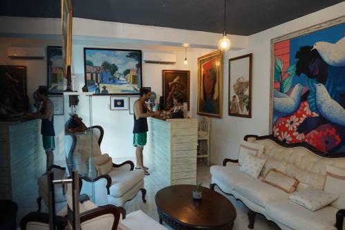 two men standing in a living room with a refrigerator at Batey Hotel Boutique in Boca Chica
