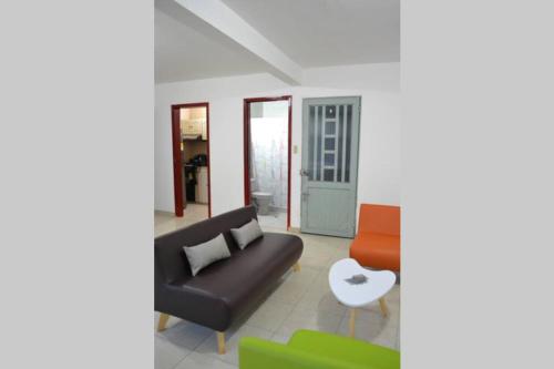 ein Wohnzimmer mit einem Sofa und einem Stuhl in der Unterkunft The Nest House - Acogedor apartamento en Duitama in Duitama