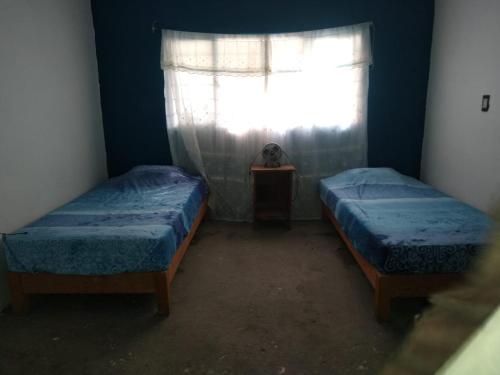 two beds in a room with a window at Aquetzali Kin Casa Privada con alberca in Cuautla Morelos