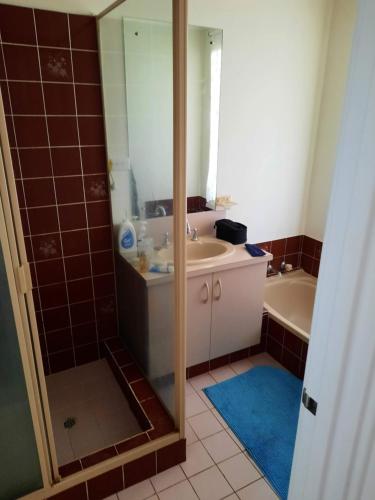 a bathroom with a shower and a sink and a tub at Comfortable Secure Homeshare in Perth