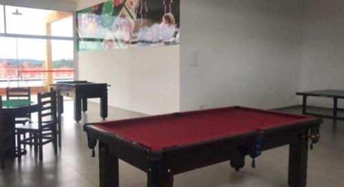a pool table in a room with tables and chairs at Catarina Home Club Mairinque SP in Sao Paulo