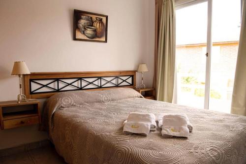 a bedroom with a bed with two towels on it at 5ta Bajada Las Grutas in Las Grutas