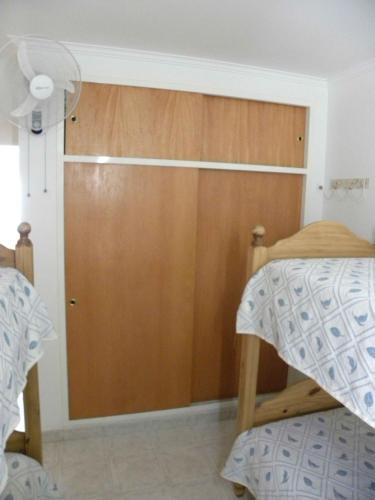 a bedroom with a wooden door and a bed at 5ta Bajada Las Grutas in Las Grutas