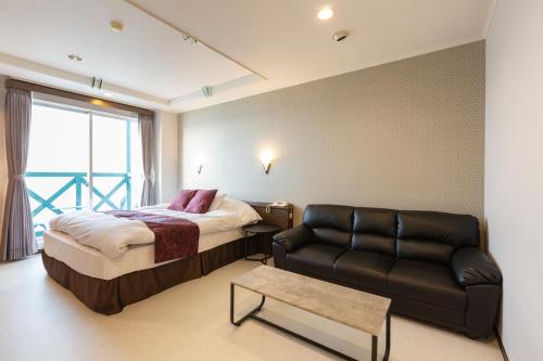 a hotel room with a bed and a couch at Hotel Liberty Matsuyama (Adult Only) in Matsuyama