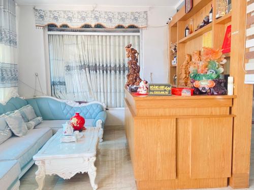 ein Wohnzimmer mit einem blauen Sofa und einem Tisch in der Unterkunft Hoàng Anh hotel in Ðưc Trọng