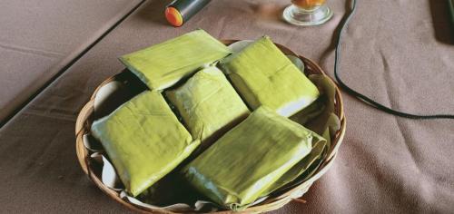 a basket filled with green tofu on top of a table at Kampoeng Karst Rammang Rammang in Kasijala