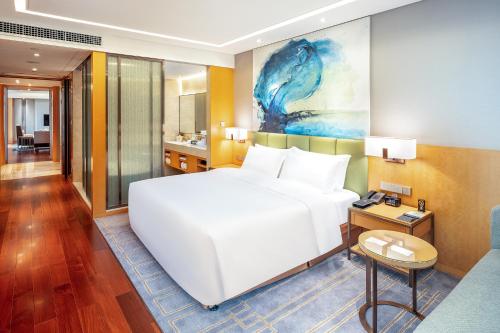 um quarto de hotel com uma cama branca e uma casa de banho em Holiday Inn Neijiang Riverside, an IHG Hotel em Neijiang