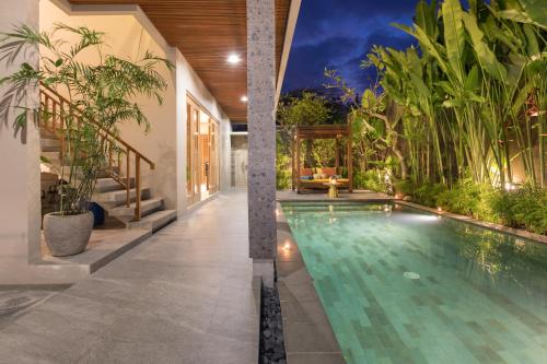 une piscine intérieure dans une maison ornée de plantes dans l'établissement Villa Daun 1 Canggu by Premier Hospitality Asia, à Canggu
