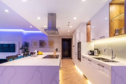 a kitchen with white cabinets and a kitchen island at Key View - Torch Tower in Dubai