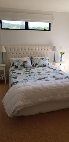 a bedroom with a large bed with a large window at Beachfront Bliss in Ohope Beach