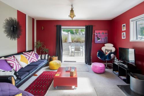 een rode woonkamer met een bank en een tv bij Number 10 Arrowtown Sleeps 12 in Arrowtown