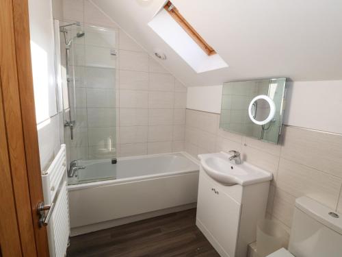 a bathroom with a bath tub and a sink at Tan Bryn 2 in Aberdaron