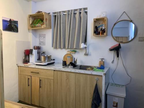 eine Küchentheke mit einem Waschbecken und einem Spiegel in der Unterkunft That day Hostel 那天旅宿 in Lanyu