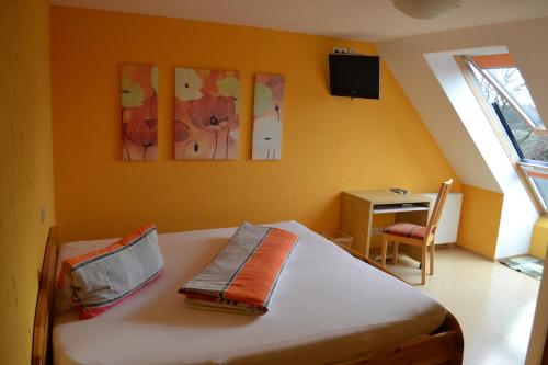 a bedroom with a bed with three paintings on the wall at Gasthof Hotel Traube in Oberndorf
