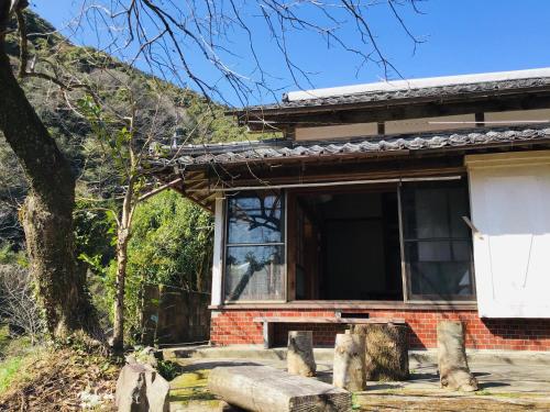 a house with a window on the side of it at 古民家宿　寝つきいいキツネ in Shimanto