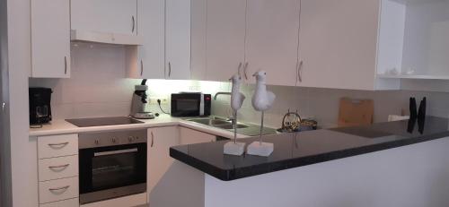 a kitchen with white cabinets and a stove top oven at Residentie Lautrec in Knokke-Heist