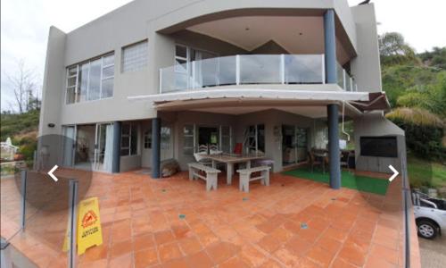 a large house with a patio in front of it at Lagoon View Villa in Knysna