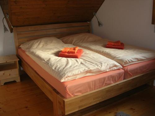 a bed with two orange pillows on top of it at Drevenica pod smrekom in Terchová