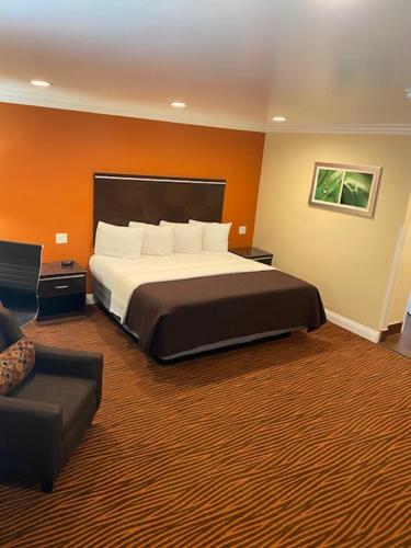 a hotel room with a large bed and a couch at Convention Center Inn & Suites in San Jose