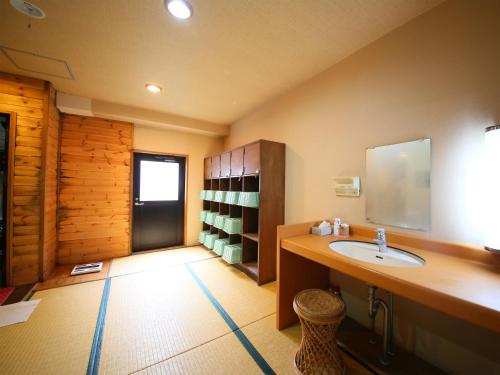 a bathroom with a sink and a mirror at Yama no Yado Meiji Onsen in Chino