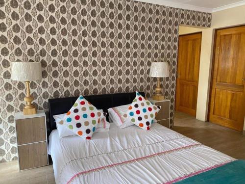 a bedroom with a bed with polka dot pillows at Elegant84 in Johannesburg