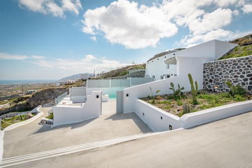 a white house with a view of the ocean at Siete Mares Luxury Suites in Imerovigli