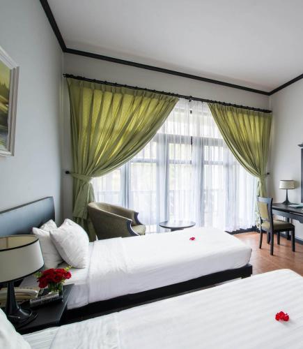 a hotel room with two beds and a desk at Lazi Beach Resort in Lagi