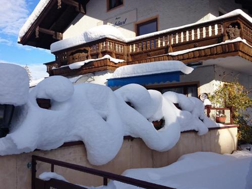 a building with snow on the side of it at Haus Neuhäusl inkl. Chiemgaukarte in Ruhpolding
