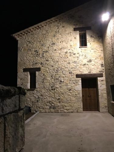 a large stone building with a wooden door at night at La Pepi house in Arcones