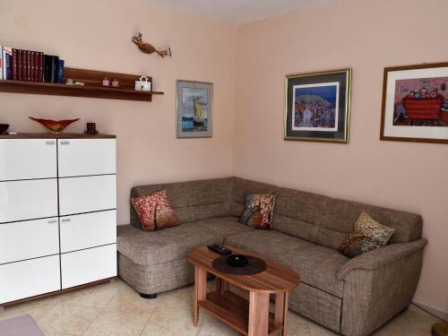 uma sala de estar com um sofá e uma mesa em Apartment Manigo em Supetar