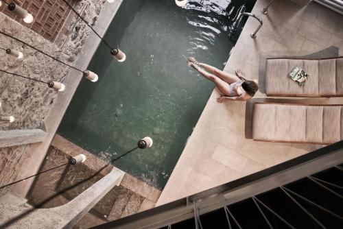 Ein Mann, der in einem Pool im Wasser schwimmt. in der Unterkunft Asomaton in Athen