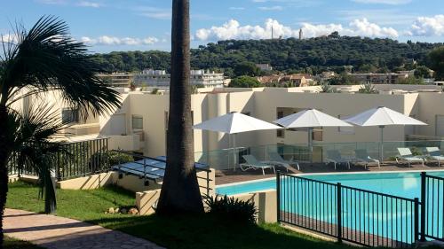 a view of a resort with a pool and palm trees at Hapimag Apartments Antibes in Antibes